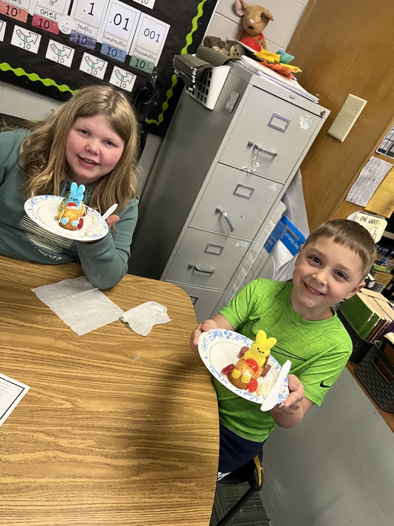 A girl in a teal hoodie and a boy in a lime green shirt hold up their colorful Peep-rider snack cake cars.