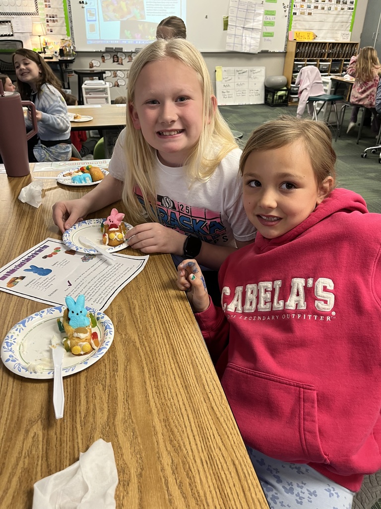 Two girls pose with their colorful Peep snack cake cars; one girl wears a bright pink Cabela's hoodie.