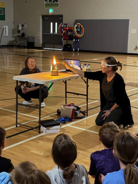 a teacher lights a flame in a lab