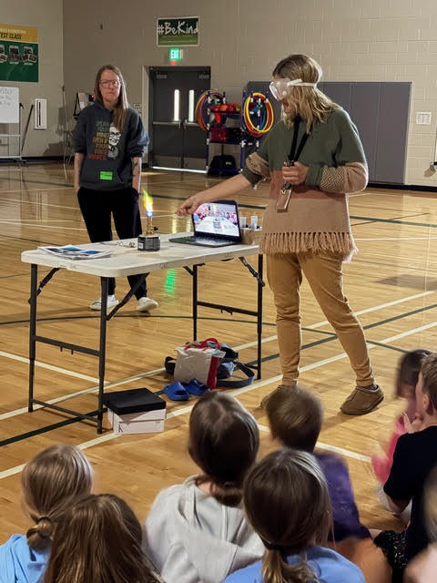 a teacher lights a flame in a lab
