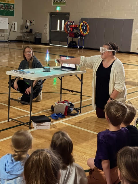 a teacher lights a flame in a lab