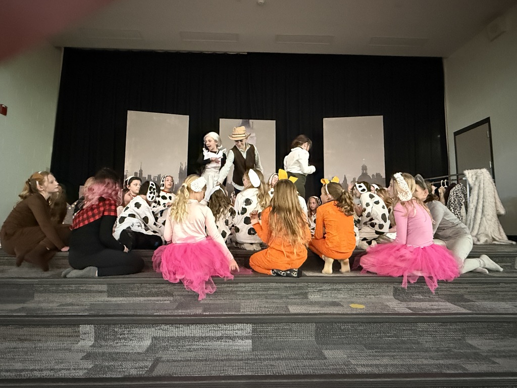 A maid, a farmer and a woman are in the. middle surrounded by kids dressed as dogs.