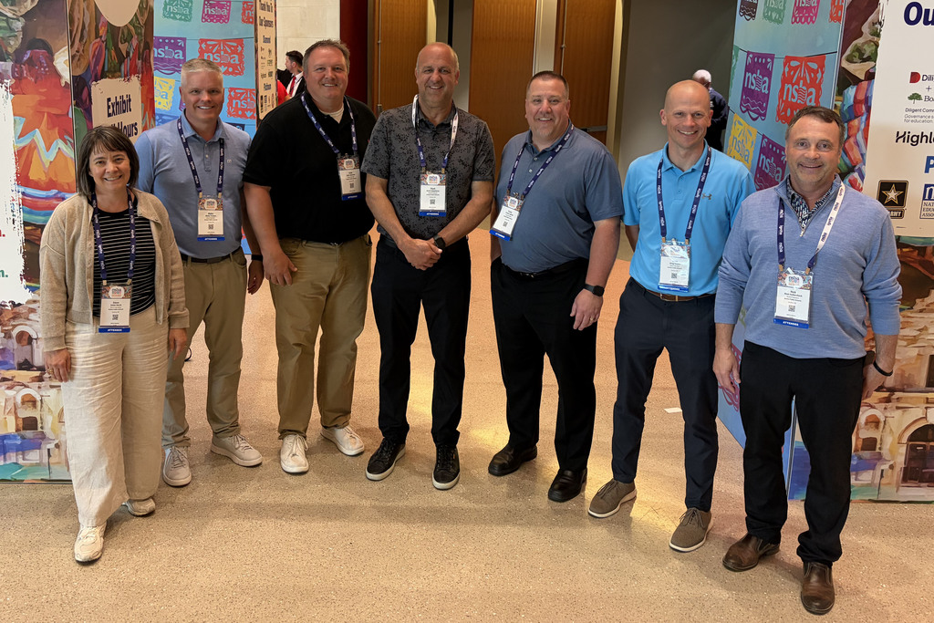 six board members and Superintendent standing outside conference event center 