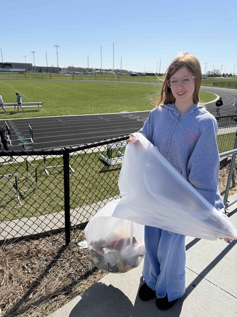 Photo of a female student posing with a trash bag.