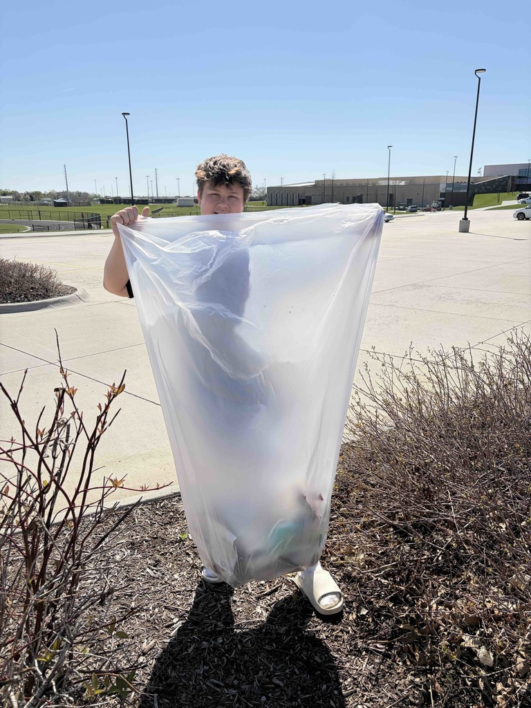 Photo of a male student posing with a trash bag.