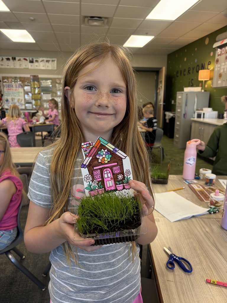 student holding grass in their classroom