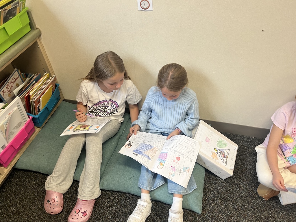 Students sitting down and reading their writing to each other.