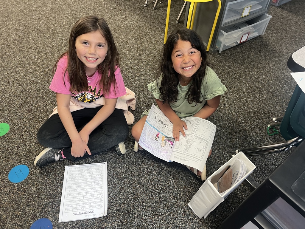 Students sitting down and reading their writing to each other.