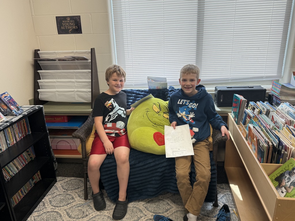 Students sitting down and reading their writing to each other.