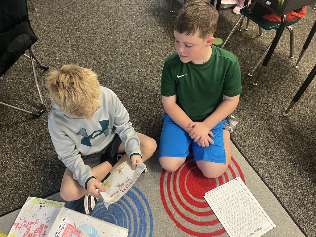Students sitting down and reading their writing to each other.
