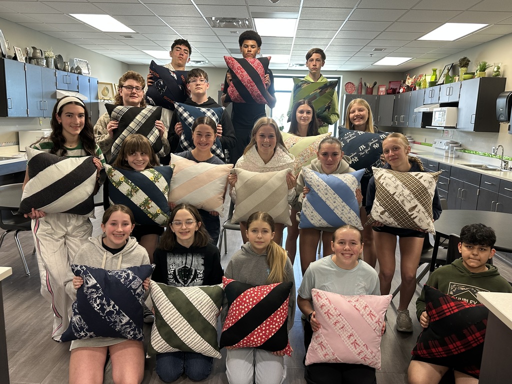 Photo of 16 middle school students lined up holding their pillows.