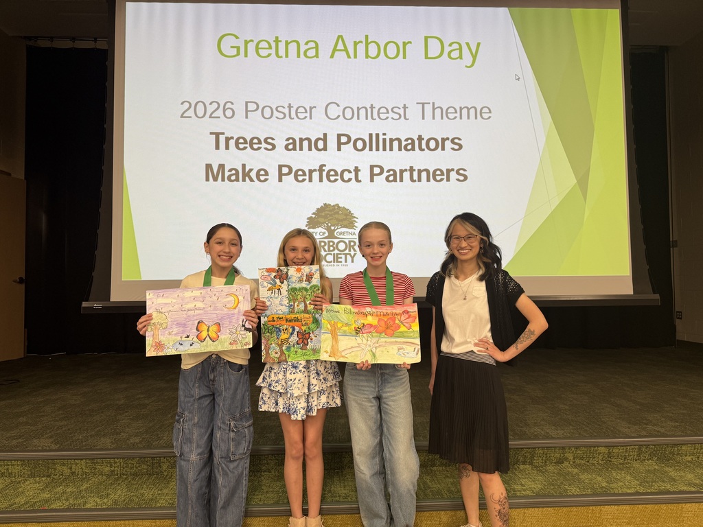 Three fifth grade girls and art teacher Miss O'Connell stand in front of a screen that says "Gretna Arbor Day 2026 Poster Contest Theme: Trees and Pollinators Make Perfect Partners." The students are holding the posters they designed.