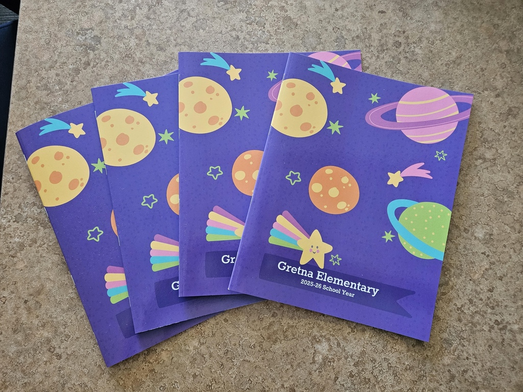 Four yearbooks that say Gretna Elementary 2025-26 School year are sitting on a gray table.