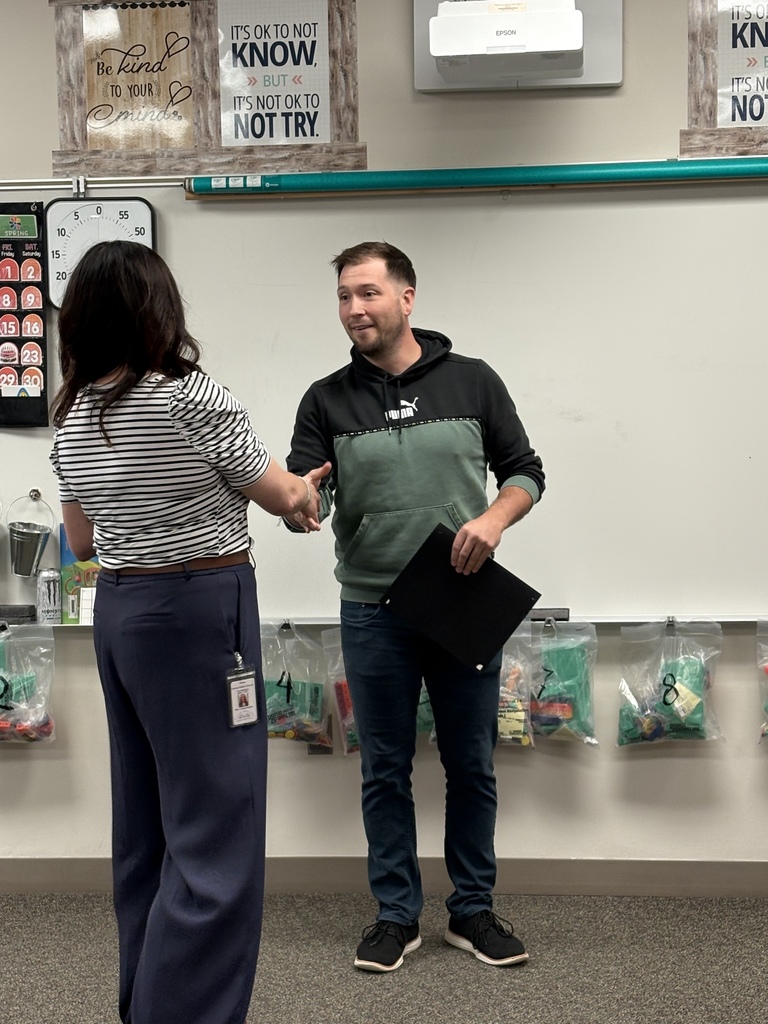Holly Radke awarding Cole Kohout the Educator of the Year Award in the classroom. 