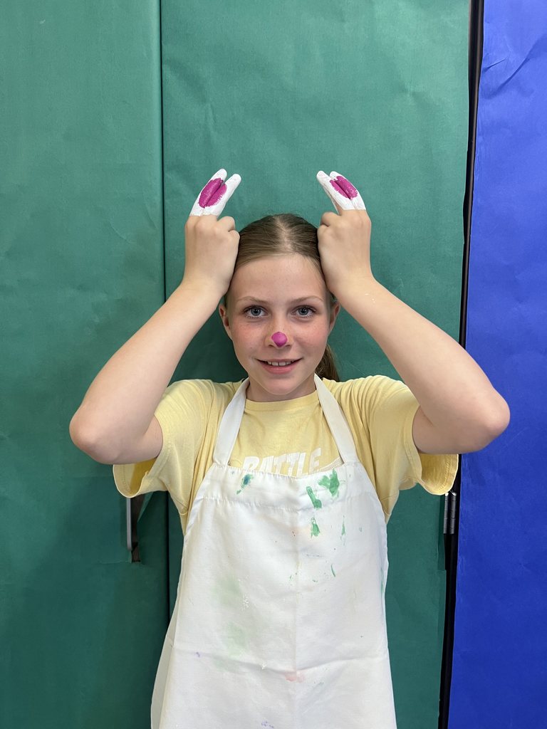 A girl making the ASL sign for bunny. 