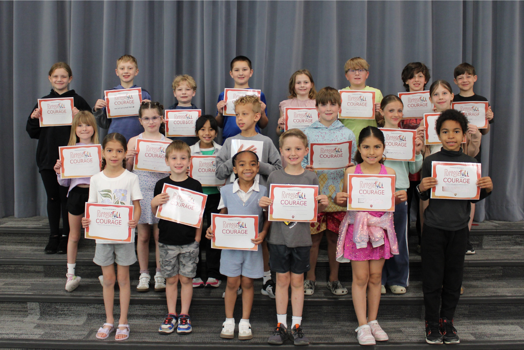 Three rows of students holding their signs for being the Student of the Month who demonstrates Courage.