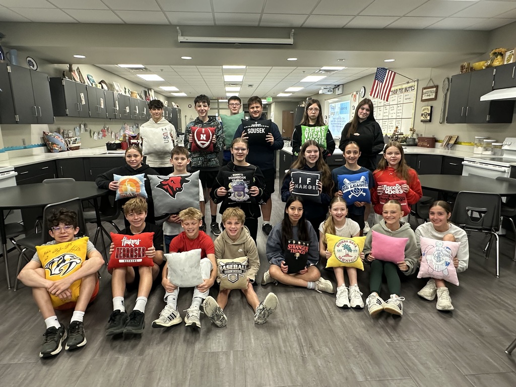 Photo of 7th grade students lined up in three rows holding their tshirt pillows.