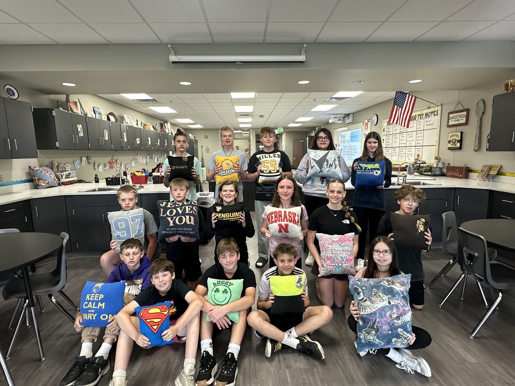 Photo of 7th grade students lined up in three rows holding their tshirt pillows.