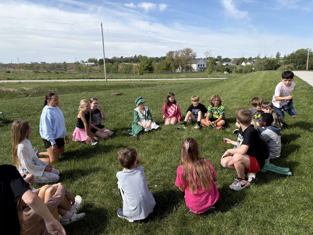 students in a circle outside on the grass