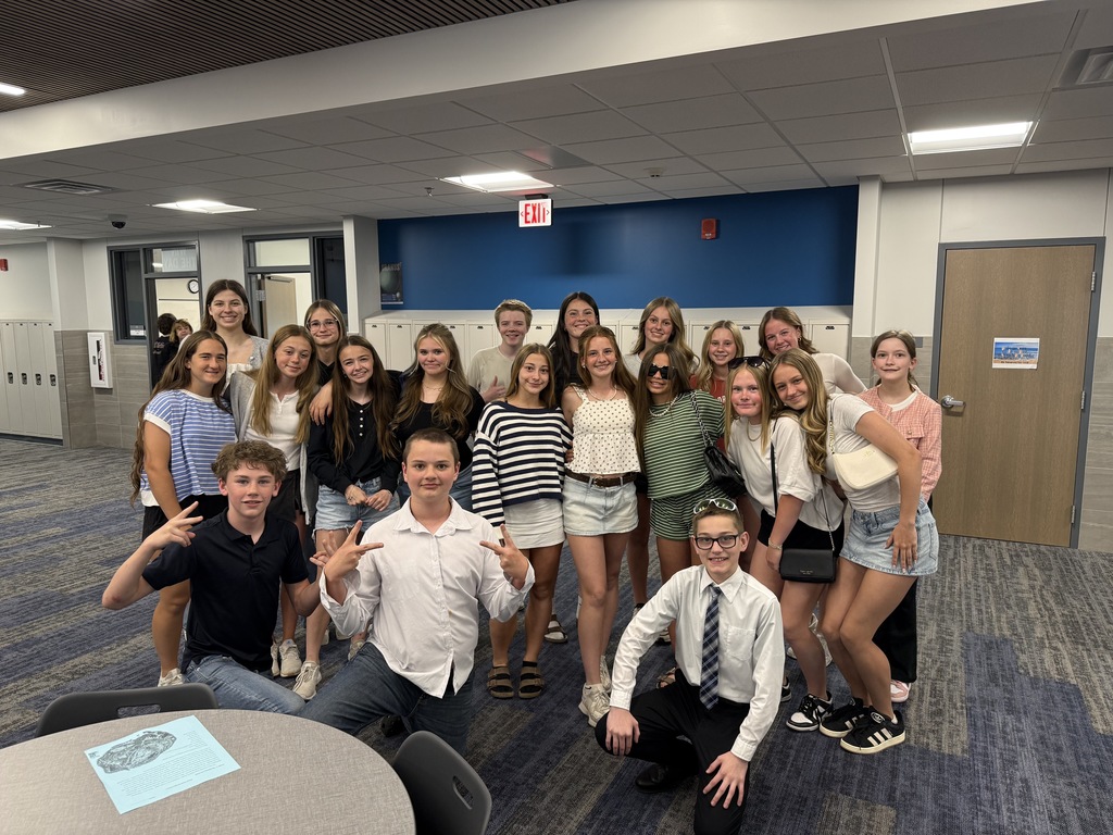A group of students gather in a hallway to pose for the camera for dress to impress day. 