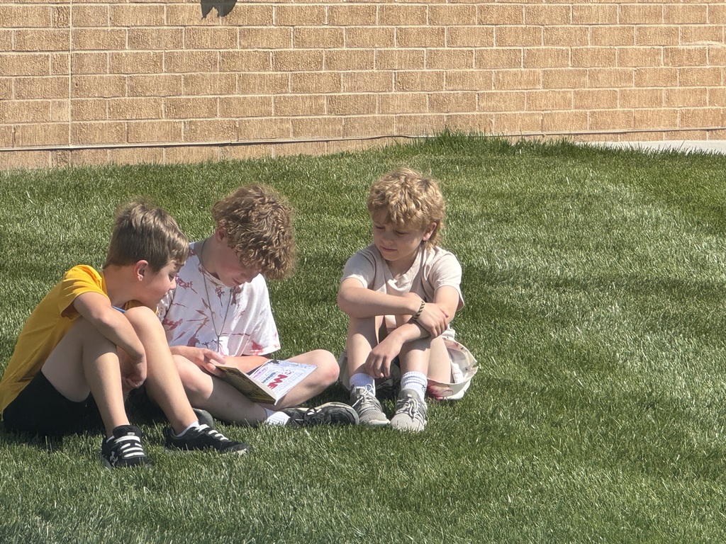 students reading outside in the outdoor classroom