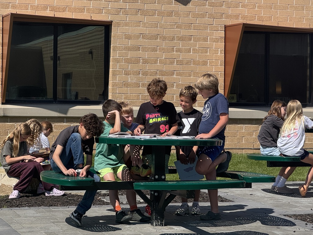 students reading outside in the outdoor classroom