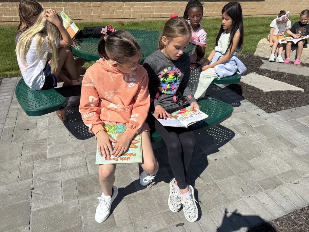 students reading outside in the outdoor classroom
