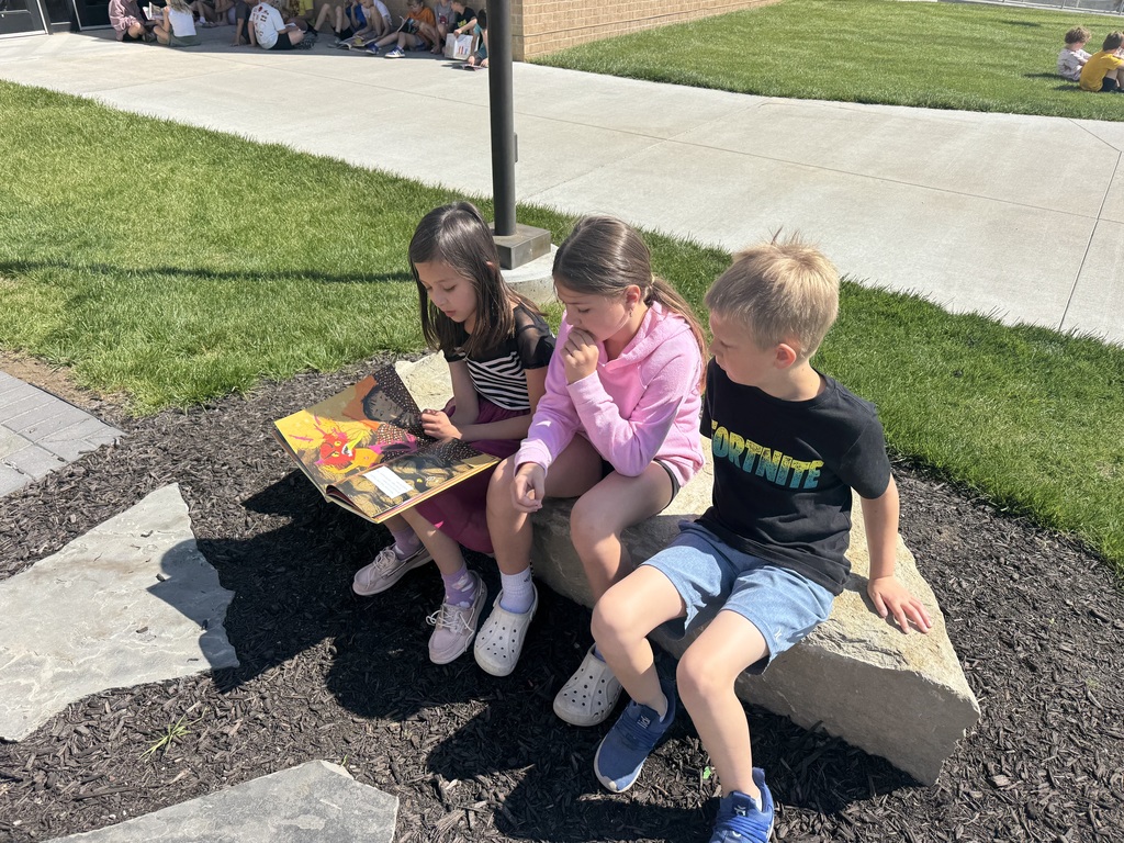 students reading outside in the outdoor classroom