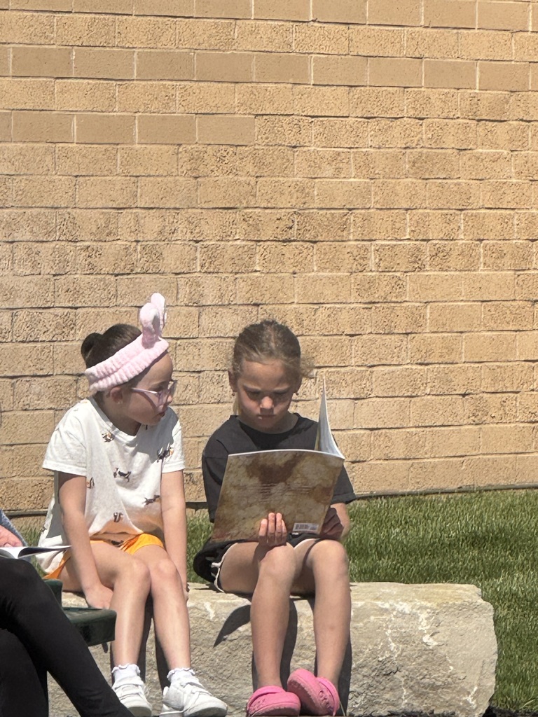 students reading outside in the outdoor classroom