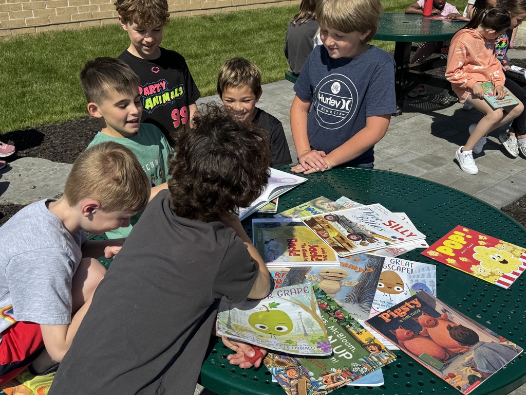 students reading outside in the outdoor classroom