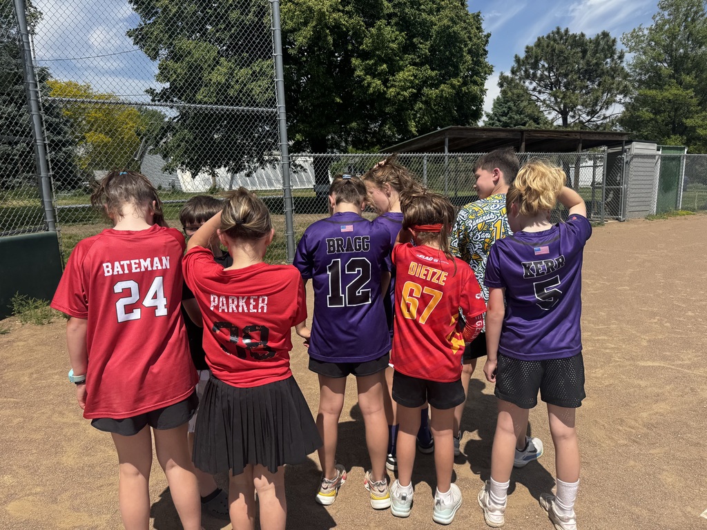 Six children standing in a row with their backs turned, showing the names "Bateman," "Parker," "Bragg," "Dietze," and "Kerr" on their jerseys.