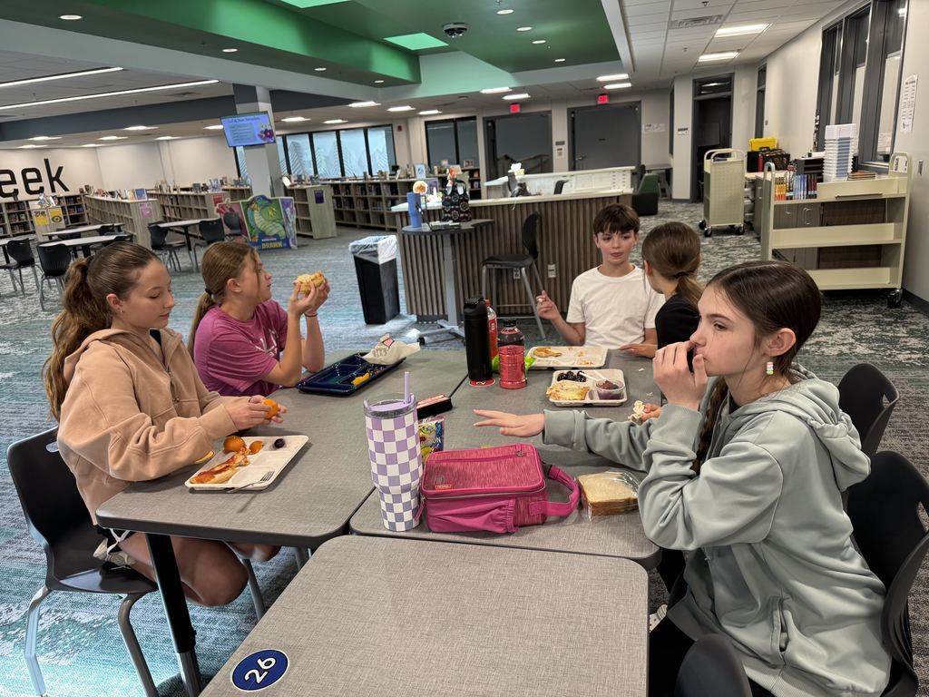 Five students sit at a table. 