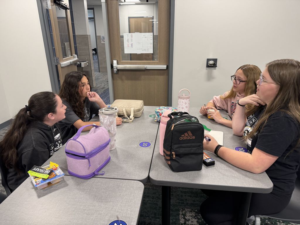 Four students sit at a table. 