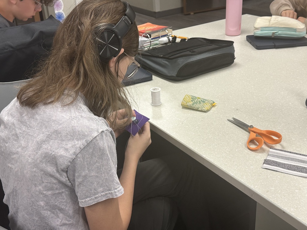 Photo of a female student sewing her buttons.