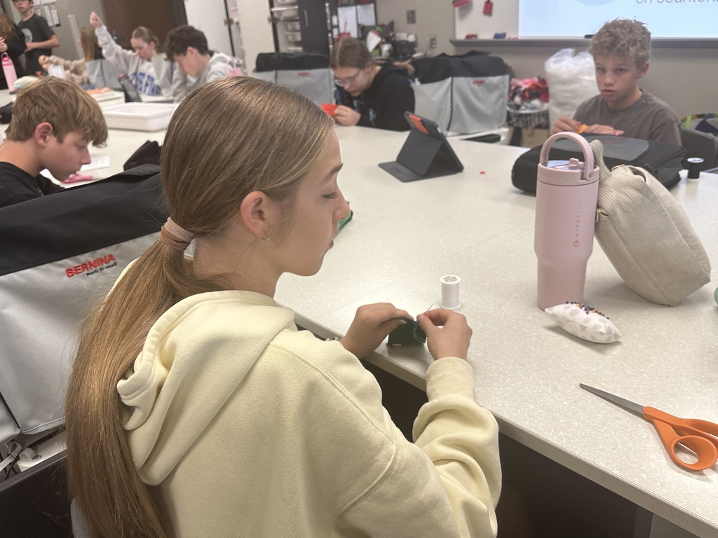 Photo of a female student sewing buttons.