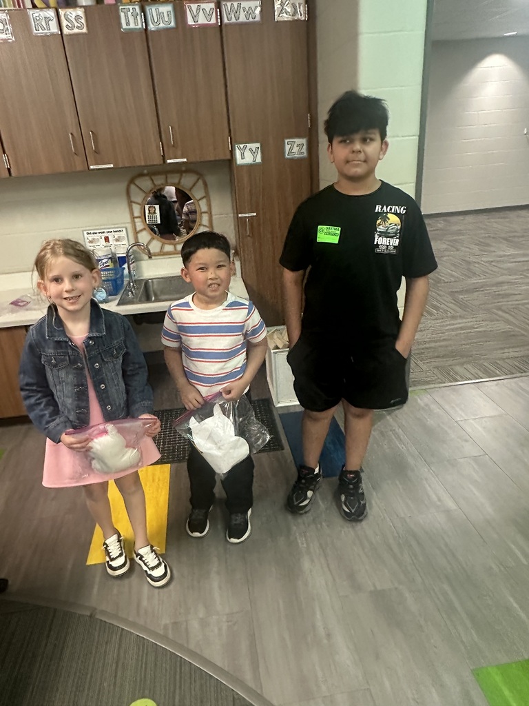 Photo of an 8th grader with two kindergarteners and their monsters.