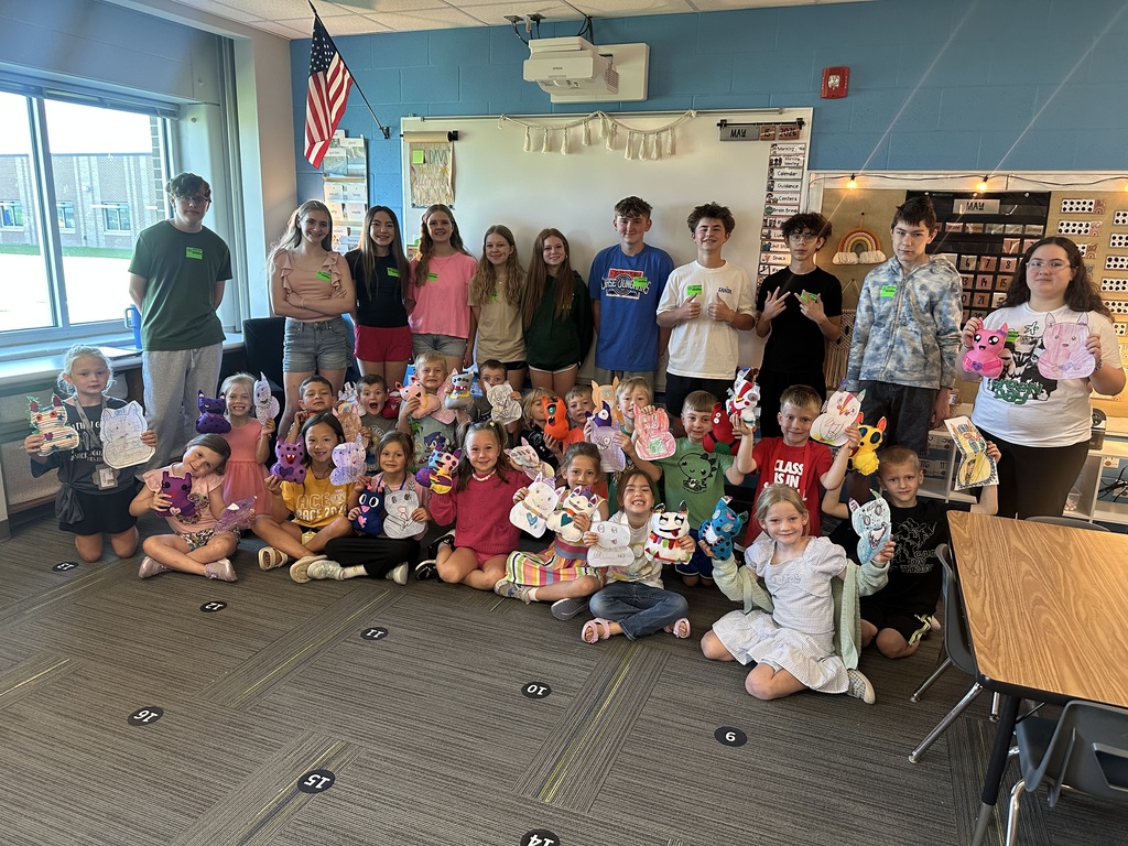Photo of 8th graders with kindergarteners showing off their monsters.