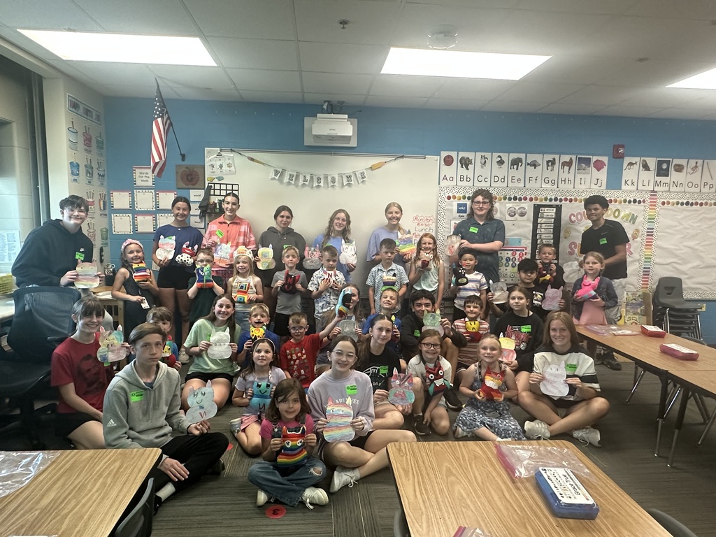 Photo of 8th graders with kindergarteners showing off their monsters.