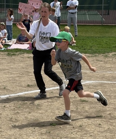 A Guardian athlete hitting the baseball and running 