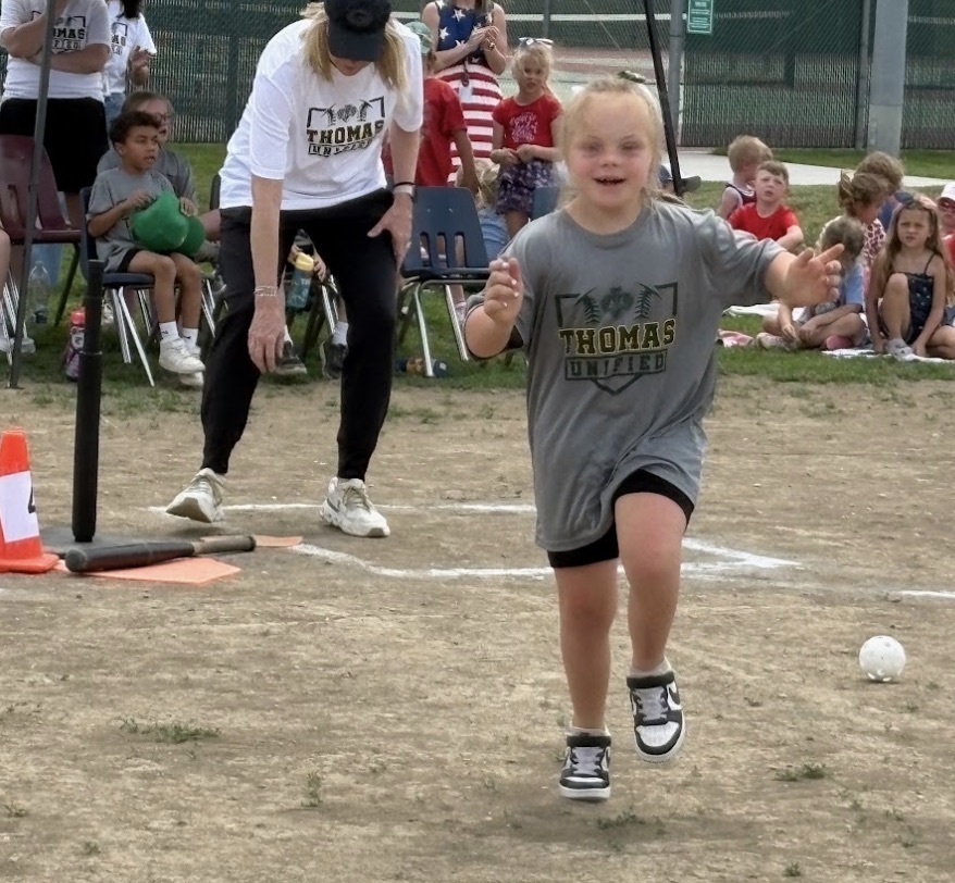A Guardian athlete hitting the baseball and running