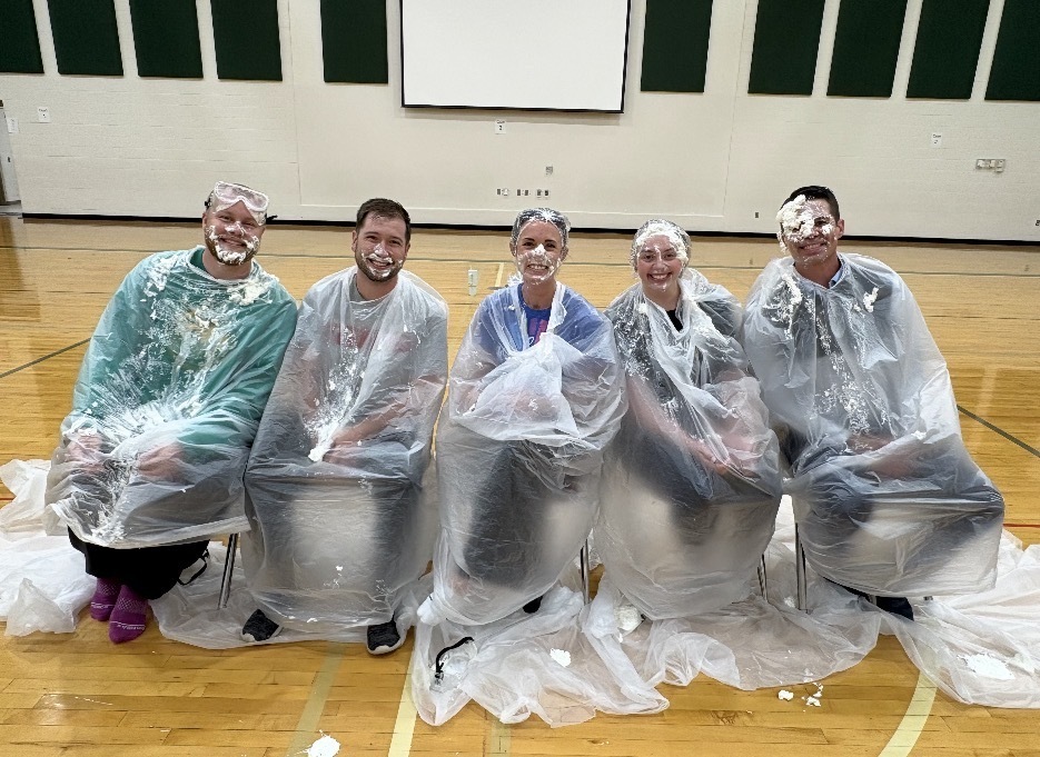 5 teachers sitting after being pied in the face