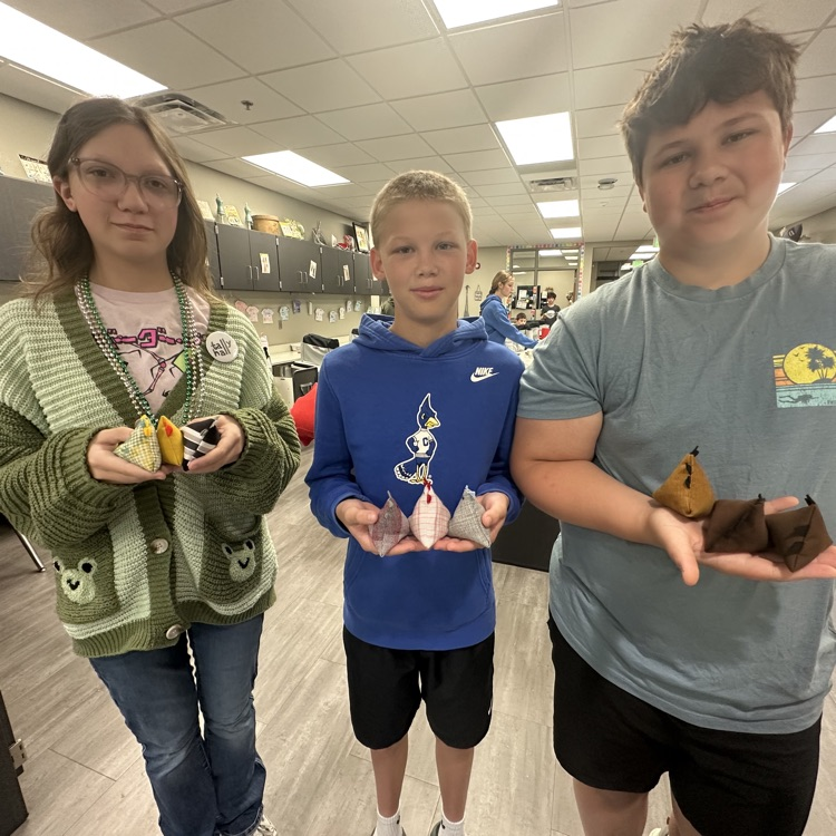 photo of three students posing holding their bean bag chickens