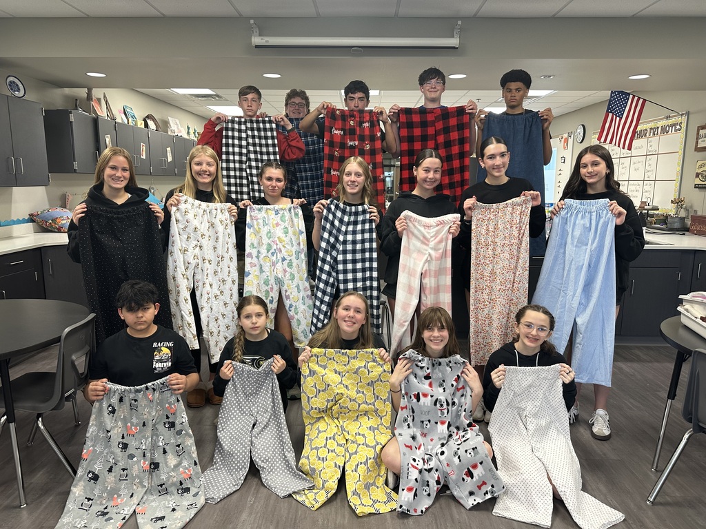 Photo of 8th grade students lined up in three rows holding their pajama pants.