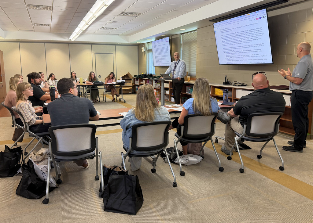 Mike Sortino Director of Student Services at the front of the room discussing with new staff members the upcoming training sessions.