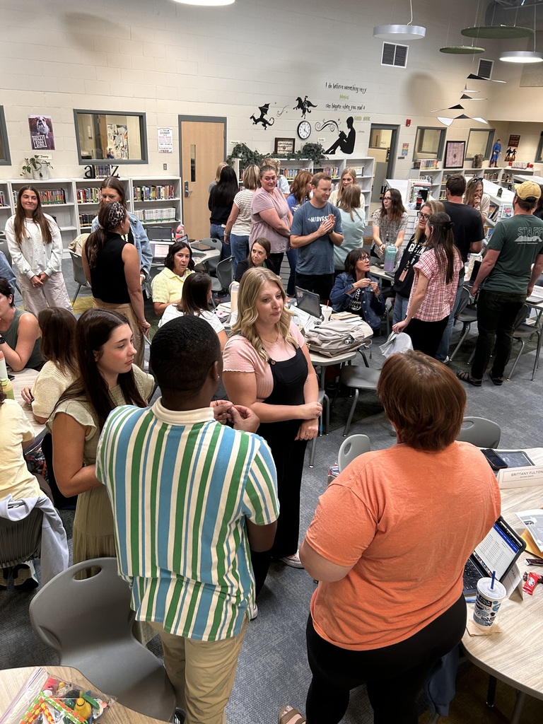 teachers collaborating in a meeting in the library. standing and talking.