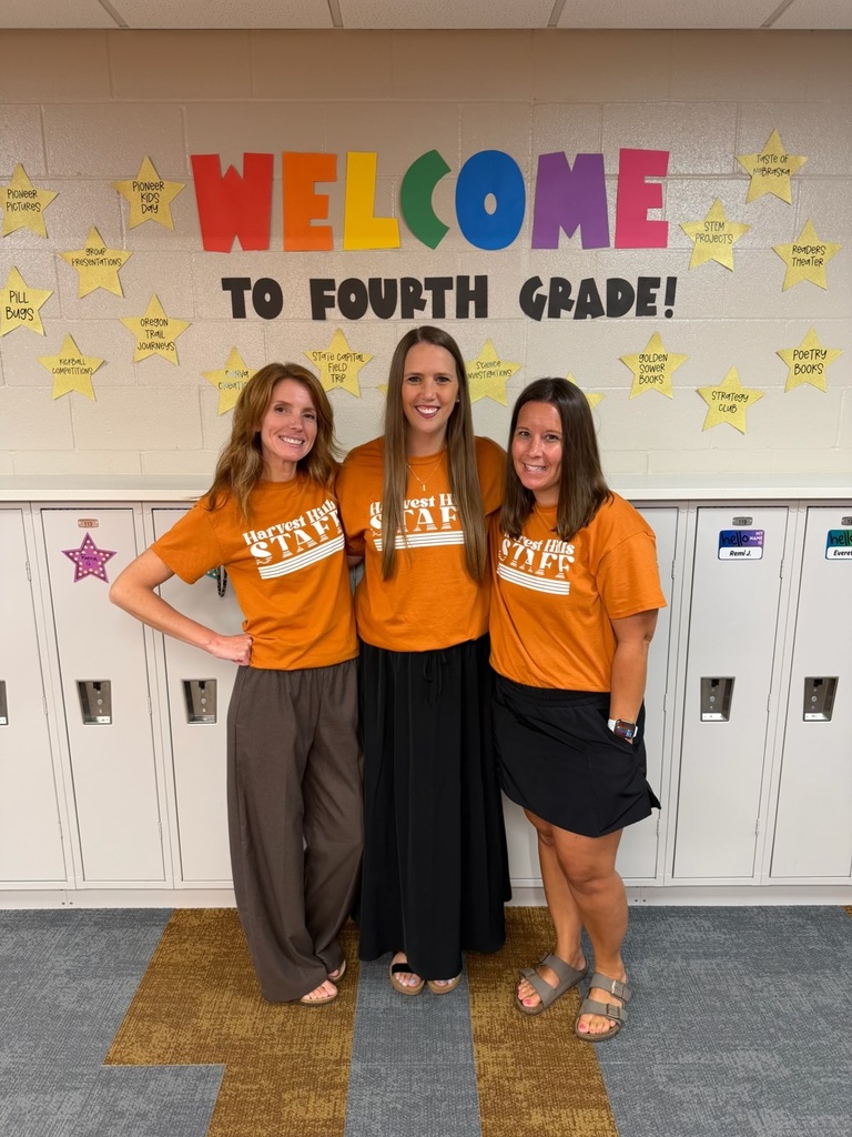 teachers smiling in matching shirts in the hallway