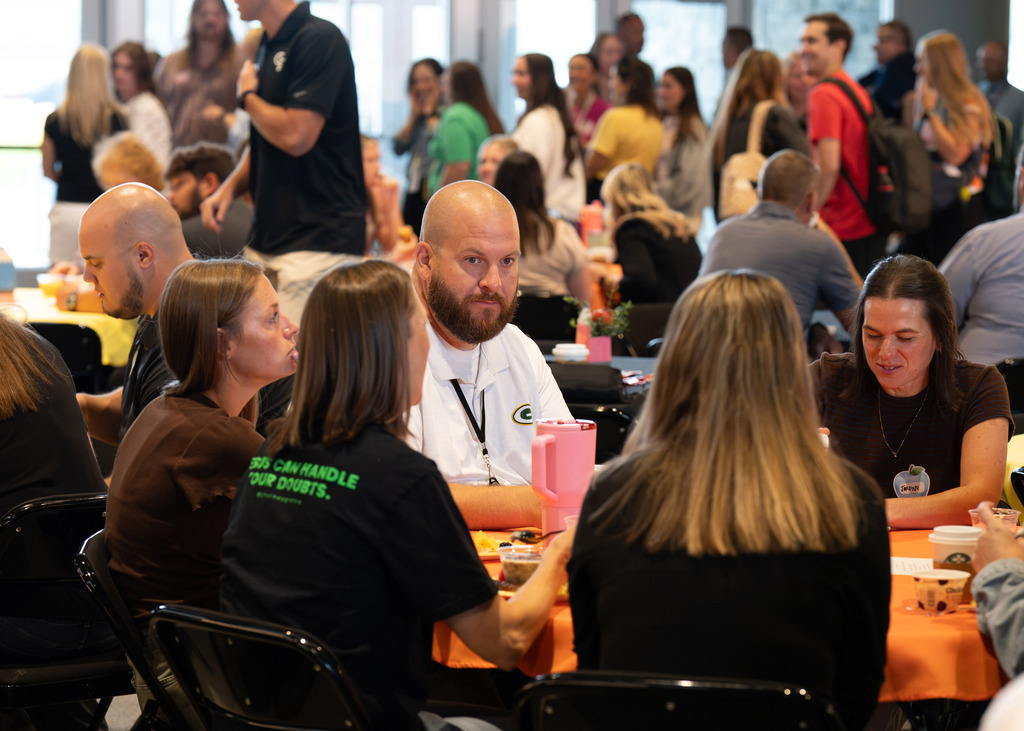 Principal Jake Runyon sitting with new staff members at Journey church breakfast for Gretna Public Schools