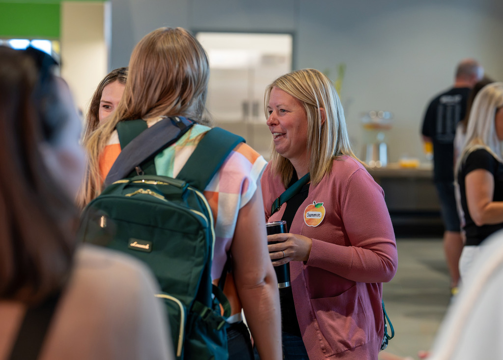 room of new staff members for Gretna Public Schools smiling and talking to each other
