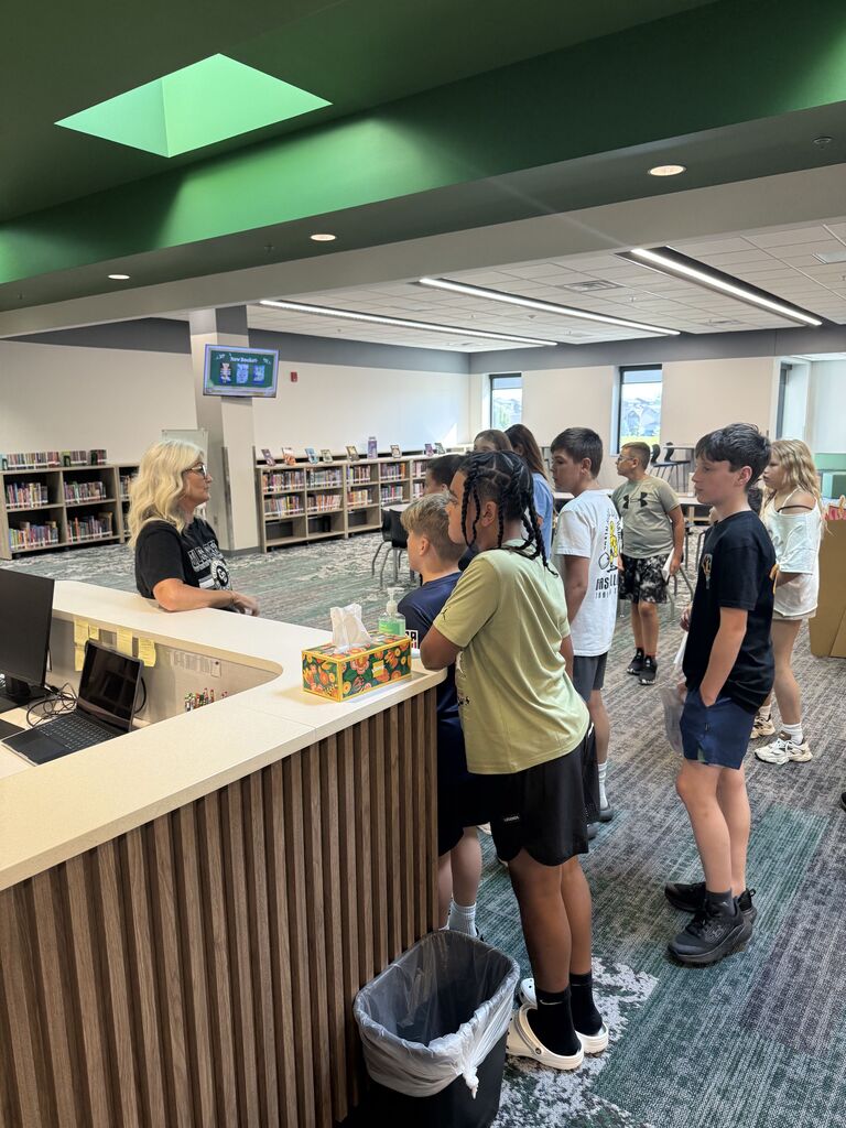 Kids in a teacher in the library. 