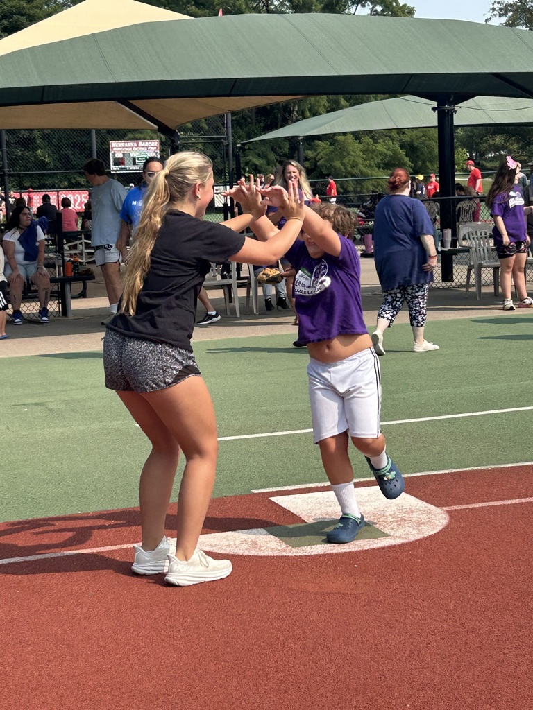 Two handed high fives from Gretna East High School softball player to a AllPlay player making it to a base